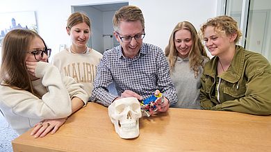 Prof. Dr. med. Matthias Feyrer bespricht mit Hilfe des selbst gebauten 3D-Modells die Bestandteile des menschlichen Schädels mit Studierenden des Studiengangs Medizintechnik