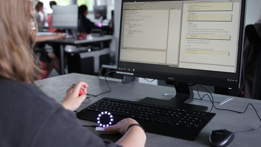 Ein Mädchen hält einen LED-Ring vor einem PC-Bildschirm