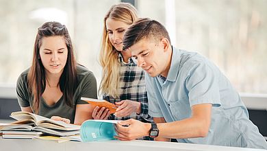 Drei Studierende in der Bibliothek