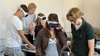 Gespannte Neugier in der Kleingruppe: Während eine Schülerin die Apple Vision Pro aufsetzt und in die virtuelle Anatomie eintaucht, beobachten ihre Mitschüler aufmerksam – der Wechsel in der Gruppe war Teil des Tandem-Formats