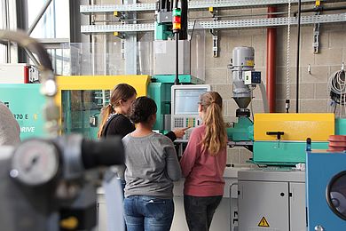 Mädchen an der Spritzgießmaschine