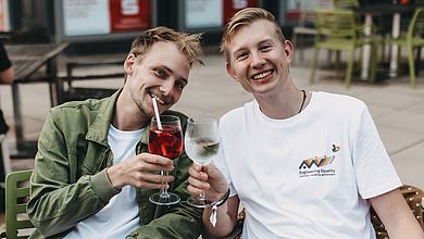 Zwei Männer stoßen mit einem Glas Wein an