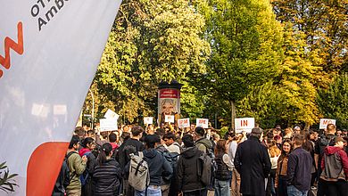 Studierende sammeln sich vor Gebäude