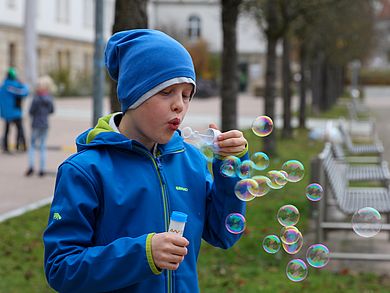 Junge macht viele Seifenblasen