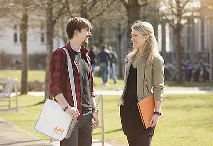 Zwei Studierende unterhalten sich am Campus