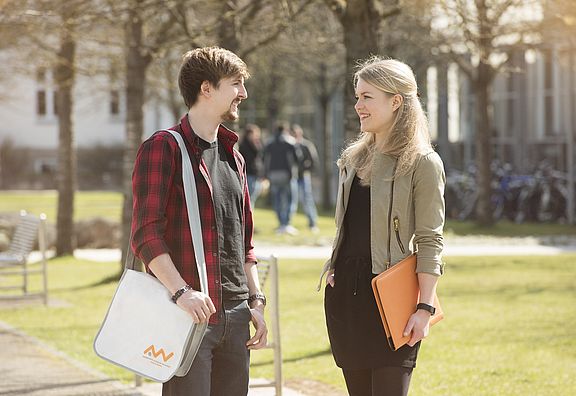 Zwei Studierende unterhalten sich am Campus