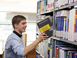 Student in der Bibliothek | Studium Patentingenieurwesen Student nimmt Buch aus dem Regal in der Bibliothek der Hochschule