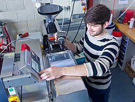 Student an der Mini-Spritzgussmaschine