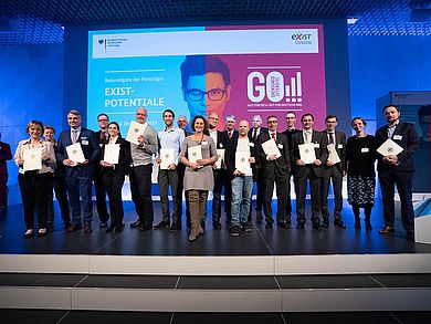 Prämierungsfeier für das Förderprogramm EXIST-Gründungskultur in Berlin: Die Vertreter der kooperierenden drei Oberpfälzer Hochschulen im Projekt Oberpfalz Start-Up HUB im Kreis weiterer ausgezeichneter Hochschulen: (von links) Prof. Dr. Christiane Hellbach, Vizepräsidentin der OTH Amberg-Weiden; Jutta Gügel, Gründerberatung an der Universität Regensburg und der Sprecher des Verbundprojektes, Prof. Dr. Sean Patrick Saßmannshausen, OTH Regensburg; Fotoquelle: BMWI/BILDKRAFTWERK/Peter-Paul Weiler Prämierungsfeier für das Förderprogramm EXIST-Gründungskultur in Berlin: Die Vertreter der kooperierenden drei Oberpfälzer Hochschulen im Projekt Oberpfalz Start-Up HUB im Kreis weiterer ausgezeichneter Hochschulen: (von links) Prof. Dr. Christiane Hellbach, Vizepräsidentin der OTH Amberg-Weiden; Jutta Gügel, Gründerberatung an der Universität Regensburg und der Sprecher des Verbundprojektes, Prof. Dr. Sean Patrick Saßmannshausen, OTH Regensburg; Fotoquelle: BMWI/BILDKRAFTWERK/Peter-Paul Weiler