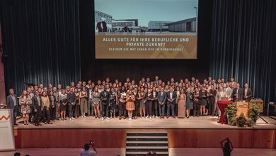 Gruppenfoto der Absolvierenden auf der Bühne