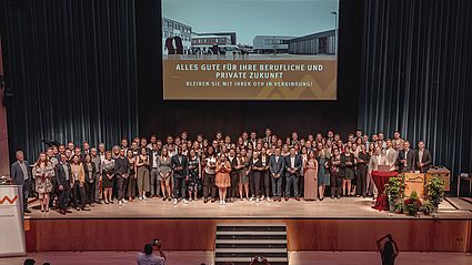 Gruppenfoto der Absolvierenden auf der Bühne