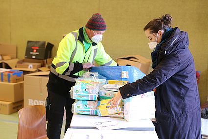 junge Frau gibt Hilfspaket ab