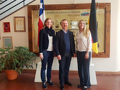 im Eingangsbereich der deutschen Schule Osorno stehen Annabelle Wolff, Ulrich Müller und Cornelia Eichinger