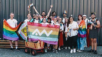 Gruppenbild mit mehreren Regenbogenfahnen