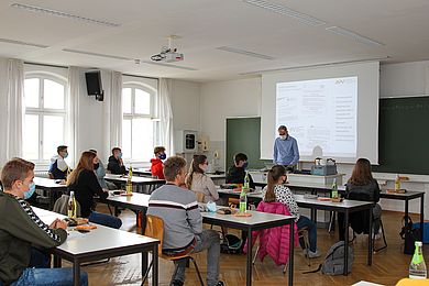 Studierende sitzen mit Masken und Abstand in einem Hörsaal