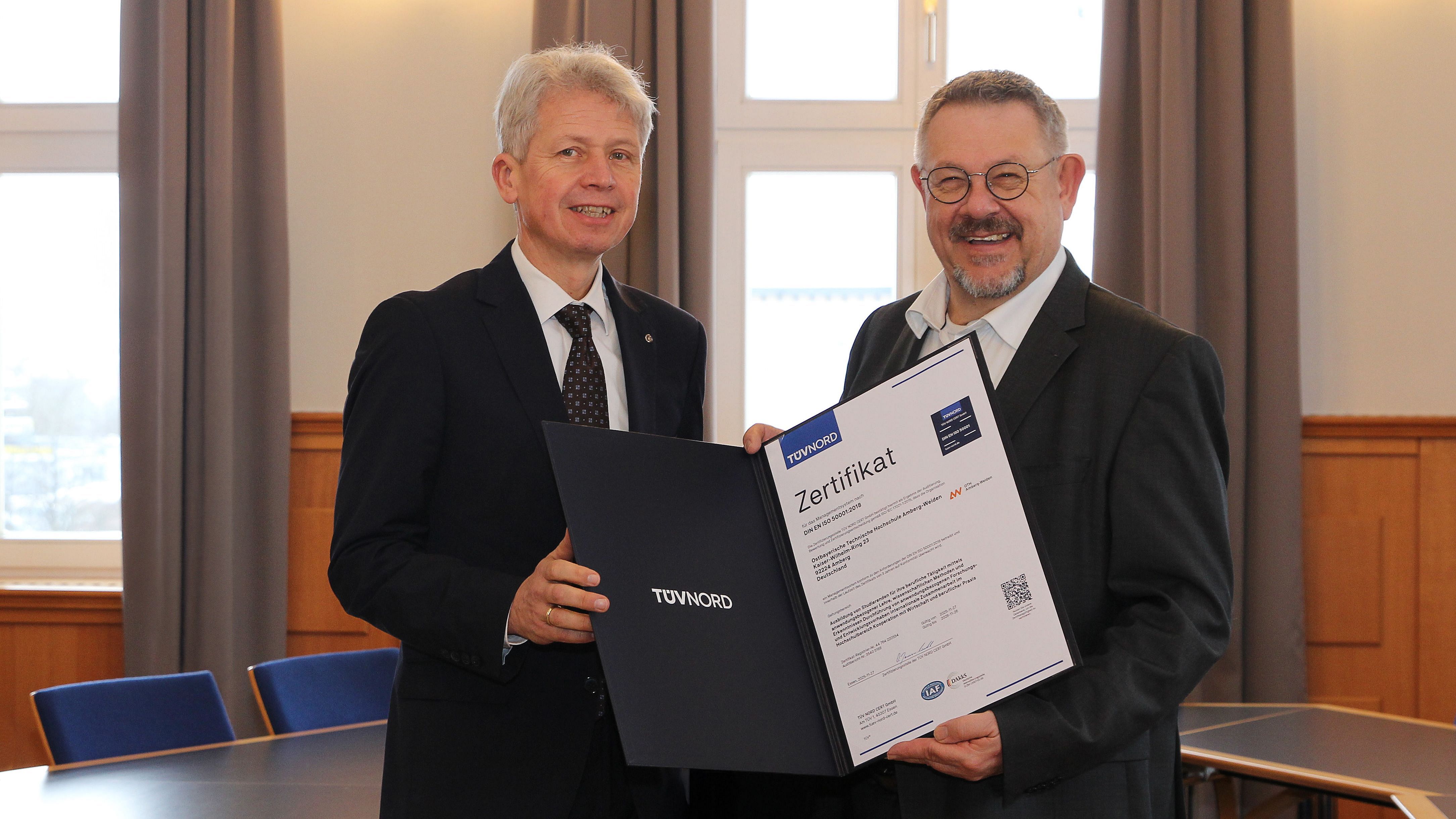 Rudolf Miller (r.) vom TÜV Nord überreicht die Urkunde zur ISO-Zertifizierung an Hochschulpräsident Prof. Dr. Clemens Bulitta (l.)