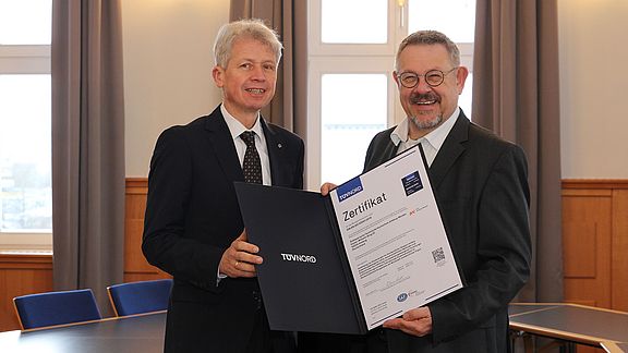 Rudolf Miller (r.) vom TÜV Nord überreicht die Urkunde zur ISO-Zertifizierung an Hochschulpräsident Prof. Dr. Clemens Bulitta (l.)