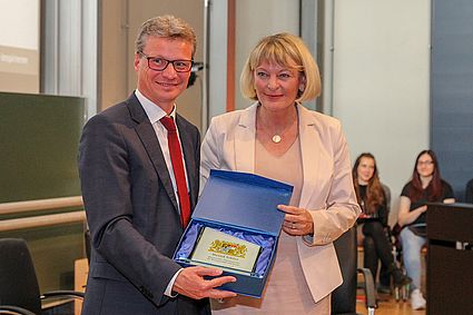 Bernd Sibler überreicht Geschenk an Andrea Klug