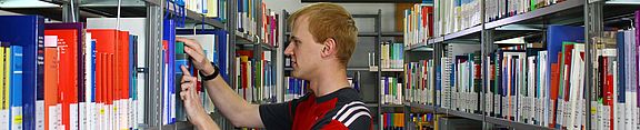 Student sucht ein Buch in der Bibliothek
