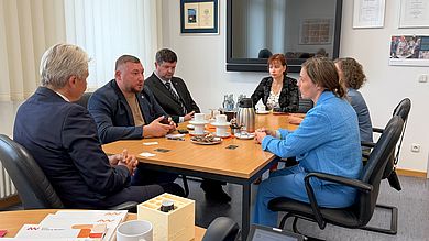 Personen sitzen um einen Tisch