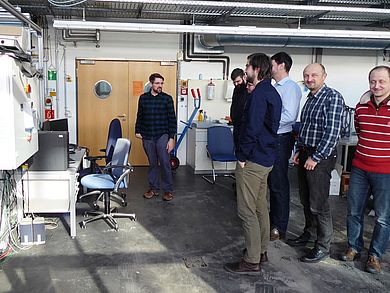 Besuchergruppe stehen vor Turbinenanlage