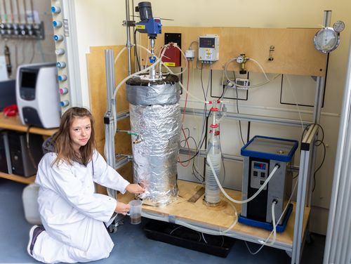 Studentin bei der Probenahme an einem Reaktor zur Gärreststabilisierung