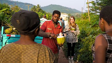 Ein Mann öffnet eine frische Kokosnuss