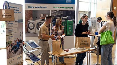 Studentin vor Messestand
