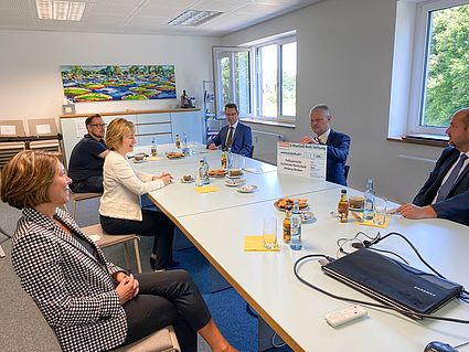 Personen sitzen um einen großen Tisch