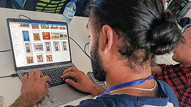 Student vor Computerbildschirm mit Kunstwerken