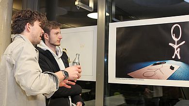 Studierende betrachten Foto