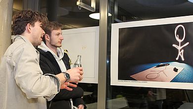 Studierende betrachten Foto