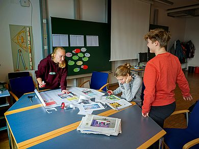 Zwei Schülerinnen stehen um Tisch