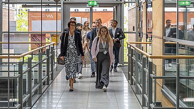 Förderer und Stipendiaten gehen gemeinsam einen Gang entlang